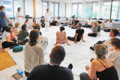 Die BesucherInnen sitzen im Kreis und folgen dem Shiatsu-Schnupperkurs von Nina und Katerina. 