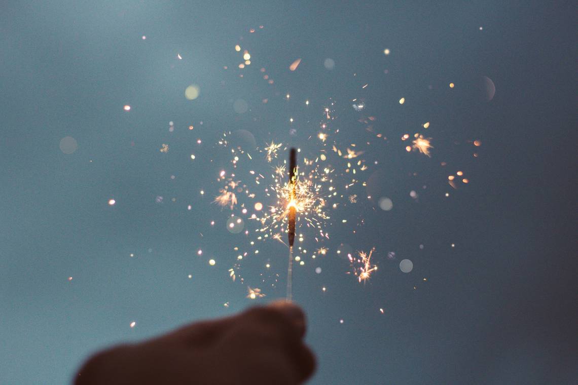 Bild einer Wunderkerze, die vor dem Nachthimmel abbrennt. Bild: unsplash