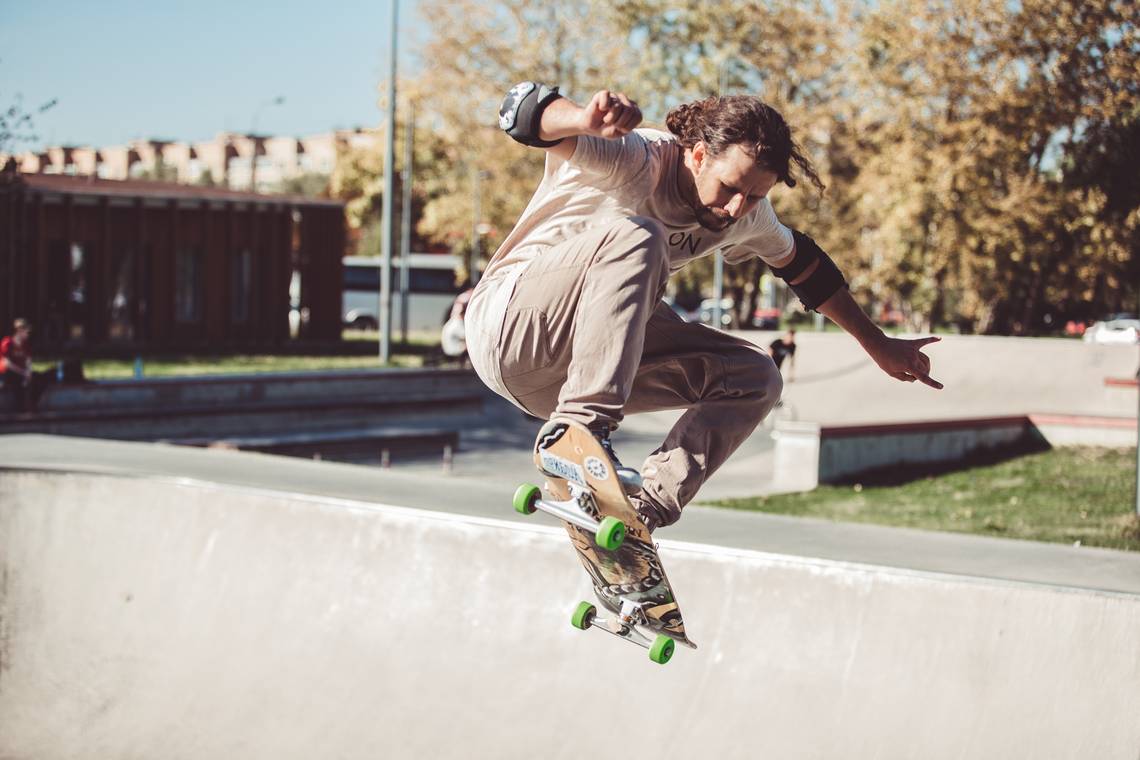 Ein junger Mann zeigt, wie er sein Skateboard beherrscht; das Bild ist von Freepik