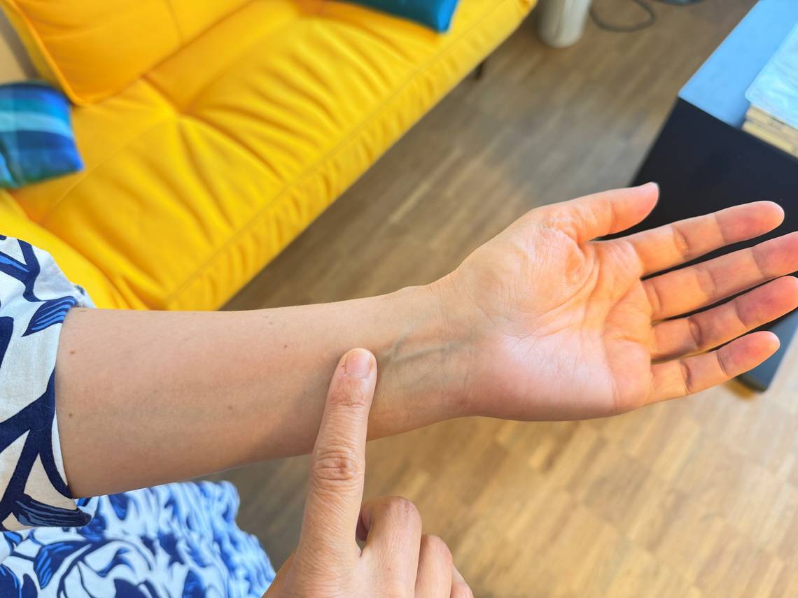 Handgelenk einer Person mit ausgestrecktem Zeigefinger, der auf einen Punkt auf der Innenseite des Unterarms zeigt; Bild: Heilpraktikerschule Luzern§