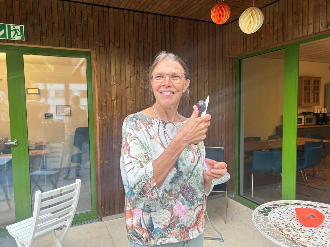 Eine Frau, Kerstin Wilcox, hält eine Pflaume. Bild: Heilpraktikerschule Luzern