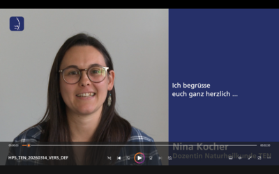 Nina Kocher vor der Kamera vor grauer Wand und blauem Textfeld mit dem Text 'Ich begrüsse euch ganz herzlich ...', Screenshot Heilpraktikerschule Luzern