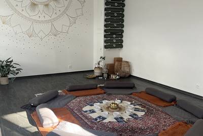 Runder Meditationsraum mit Sitzkissen und Decken.