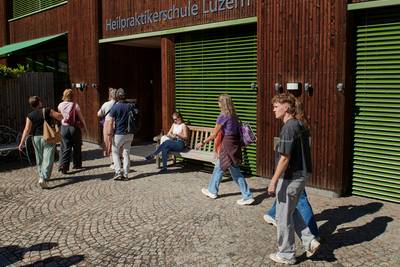 BesucherInnen gehen über den Vorplatz zum Eingang der Heilpraktikerschule Luzern.